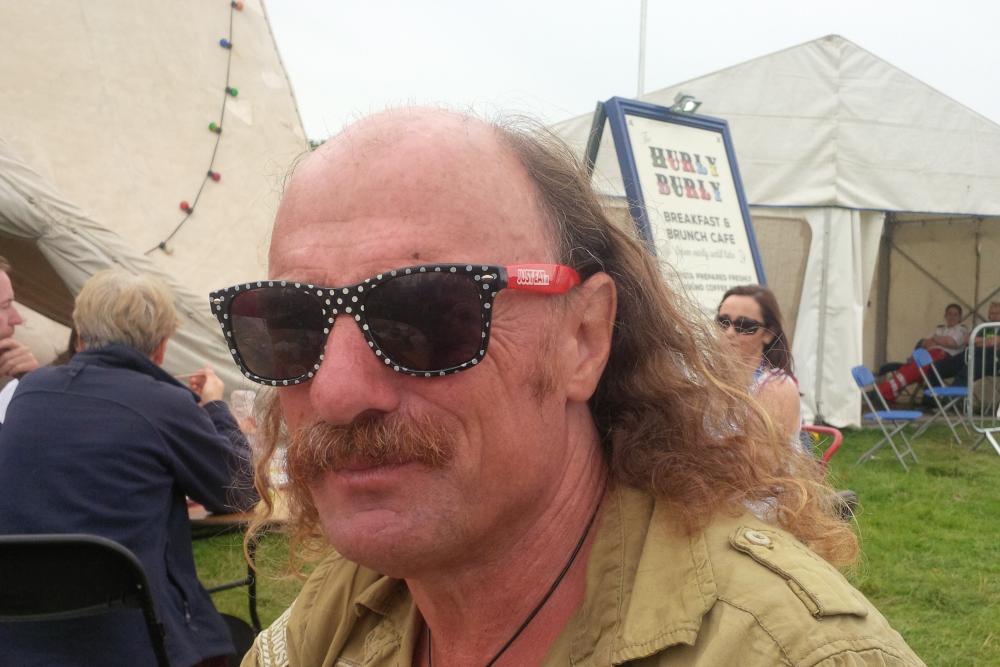 Man wearing sunglasses at a festival.