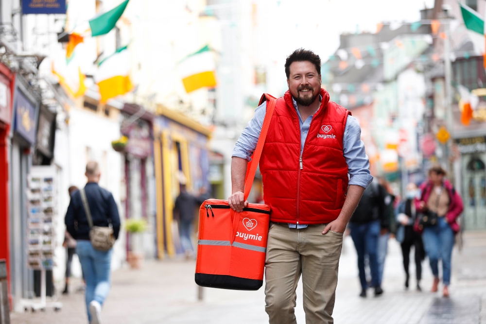 Man wearing red gillet jacket and delivering food.