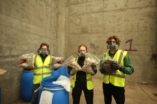 Three young people recycyling cigarette butts into sustainable plastic.