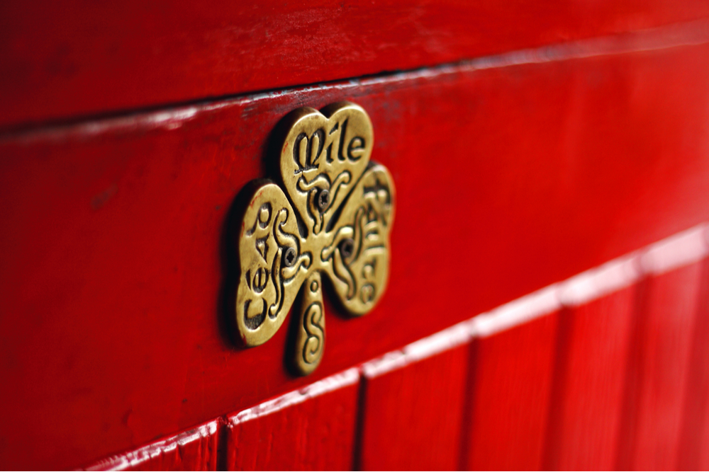 Royalty-free stock photo ID: 1732860071 Irish phrase of welcome, Céad Míle Fáilte, A hudred thousand welcomes, written on a lucky shamrock plaque on a red door, Galway, Ireland.