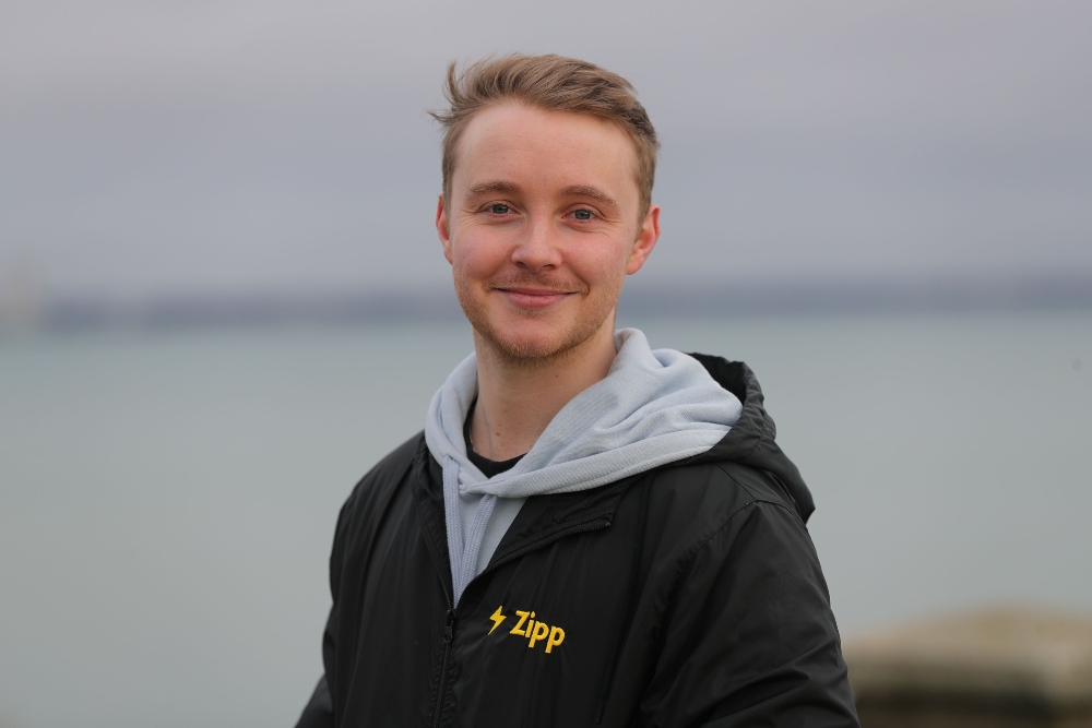 Young man in grey and black hoodie.