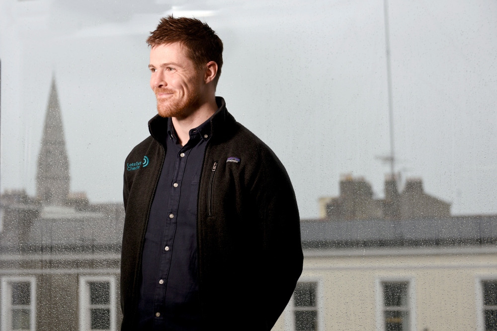 Man standing at a rainy window.