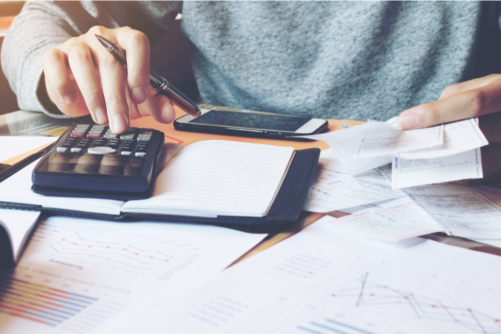 Man using calculator and calculate bills in home office.