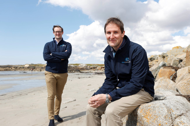 Two men sitting on a beach in Galway.