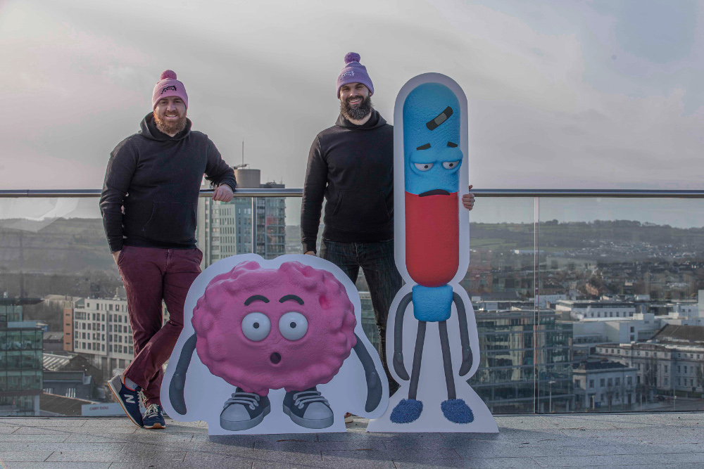 Two men on a rooftop in Cork with animated characters.