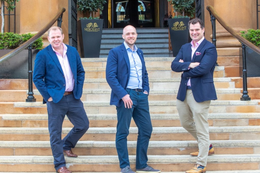 Three men standing on steps.