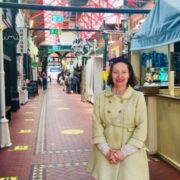 Woman in cream coat standing in George's Street Arcade, Dublin.