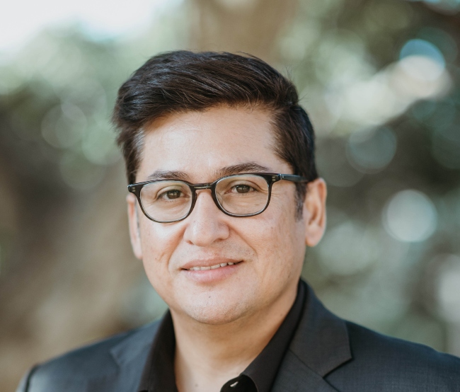 Dark haired man wearing glasses.