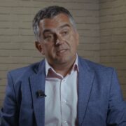 Dark haired man in blue jacket.