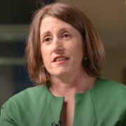 Dark haired woman in green dress.