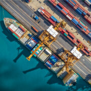 Logistics and transportation of Container Cargo ship and Cargo plane with working crane bridge in shipyard, logistic import export and transport industry background.