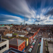 Clouds above Dublin businesses with spire at centre.