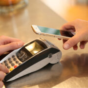 Person paying with their mobile device at a till.