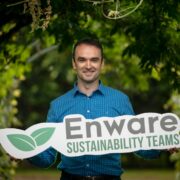 Man in forest holding sign saying Enware.