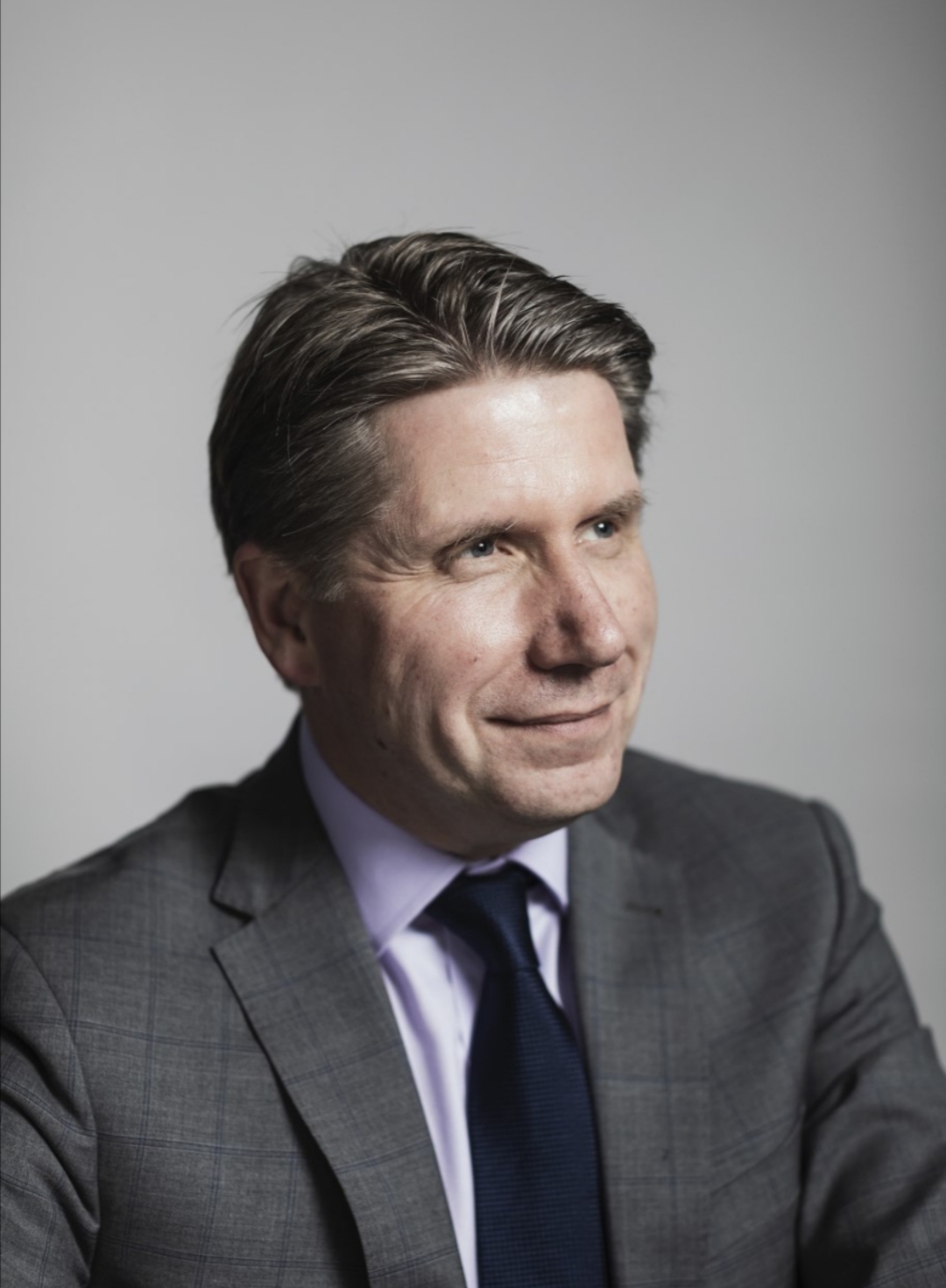 Dark-haired man in grey suit.