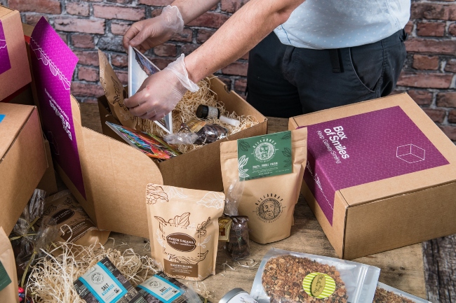 Person packing a Box of Smiles.