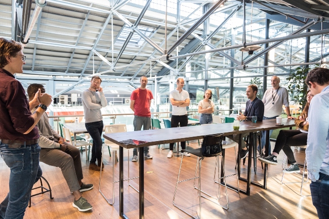 Group of people standing around a table.