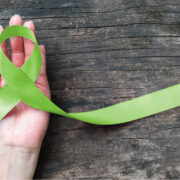 Lime green ribbon on a hand to mark World Mental Health day.