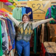 Young woman at clothing stand in market.