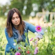 Woman working with flowers in a garden.