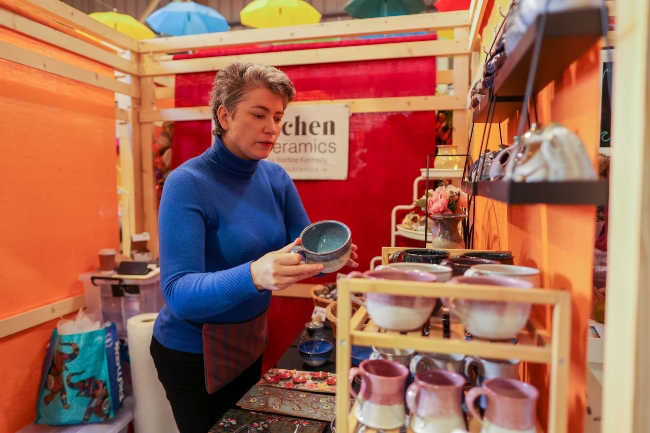 Woman selling pottery in a market.