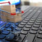 Shopping cart with cardboard boxes on laptop.
