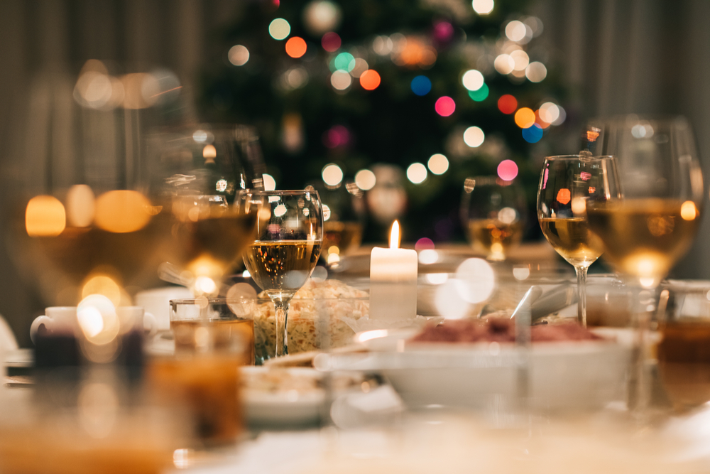 Drinks on a table in front of a Christmas tree.