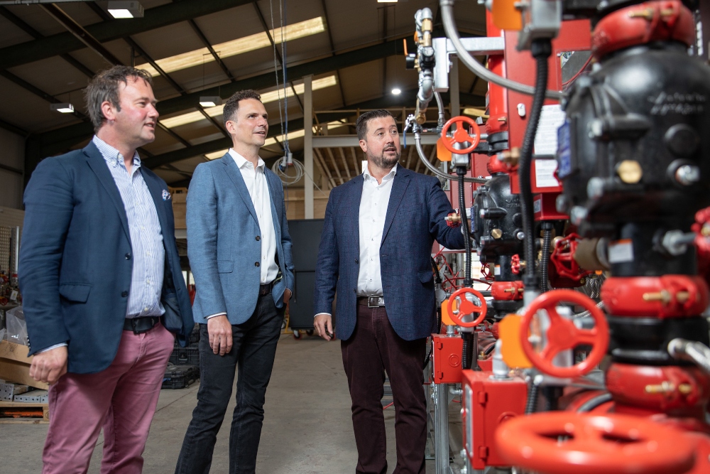 Three men looking at machinery.