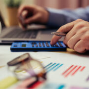 Businessman working on desk office with using a calculator to calculate the numbers.