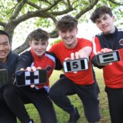Group of school boys holding a cup.