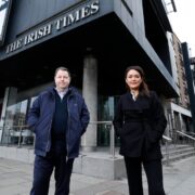 Man and woman standing in front of Irish Times building in Dublin.