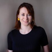 Woman with red hair, navy top.
