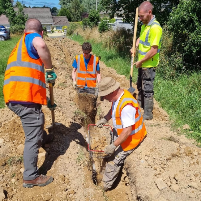 Men digging a trench for fibre cable.