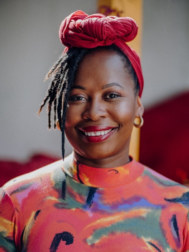 Smiling woman in colourful dress.