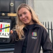Fair-haired woman holding a smartphone.