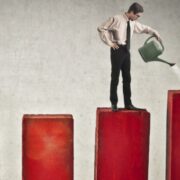 Man watering scaling bar charts.