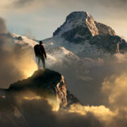 Man standing on a mountain peak.