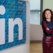 Woman standing next to LinkedIn logo.