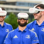 Three rugby players wearing VR headsets.