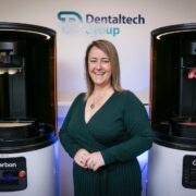 Woman standing beside 3D printing machines.