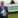 Man in suit standing in front of Lakeland Dairies sign.