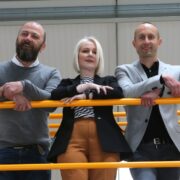 Two men and a woman in an IT recycling facility.