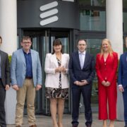 Four men and two women outside an Ericsson building.