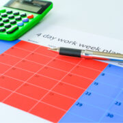 4 day work week calendar with pen and calculator.