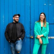 Man and woman in front of a blue door.