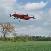 Red drone flying over Irish field.