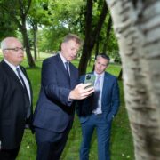 Three men in suits in a forest.