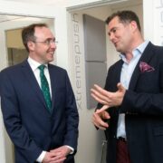 Two men in suits talking.