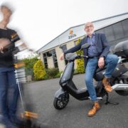 Man sitting on an electric moped.