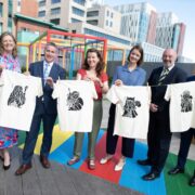 3 women and 3 men holding white t-shirts.